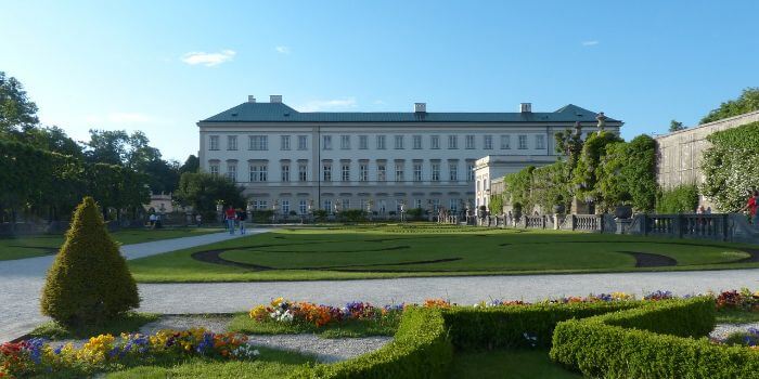 Das Schloss Mirabell in Salzburg mit einem grünen Garten davor