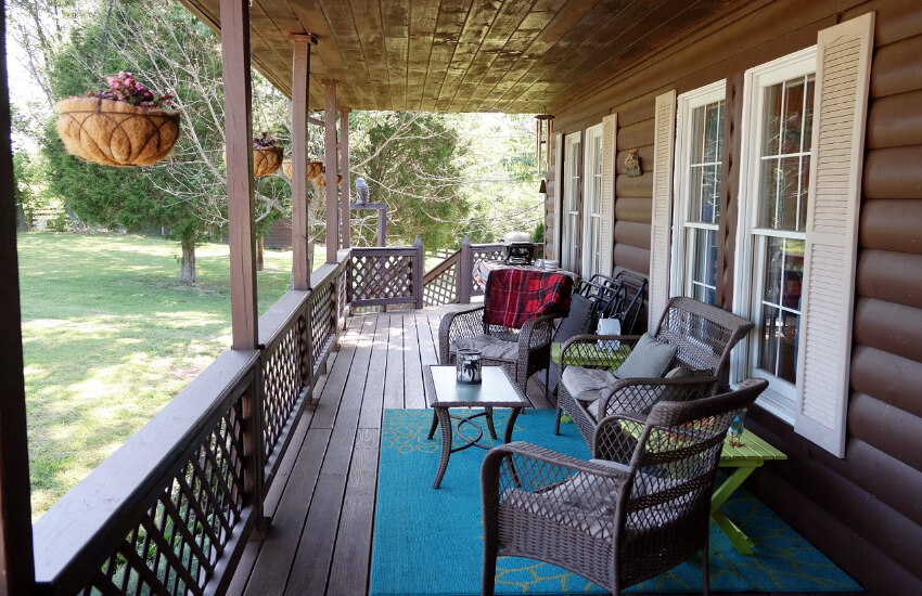Eine Terrasse eines Ferienhauses mit Rattanstühlen.