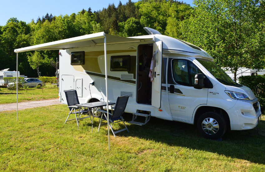 Ein Wohnmobil parkt auf einer Wiese innerhalb eines Campingplatzes.