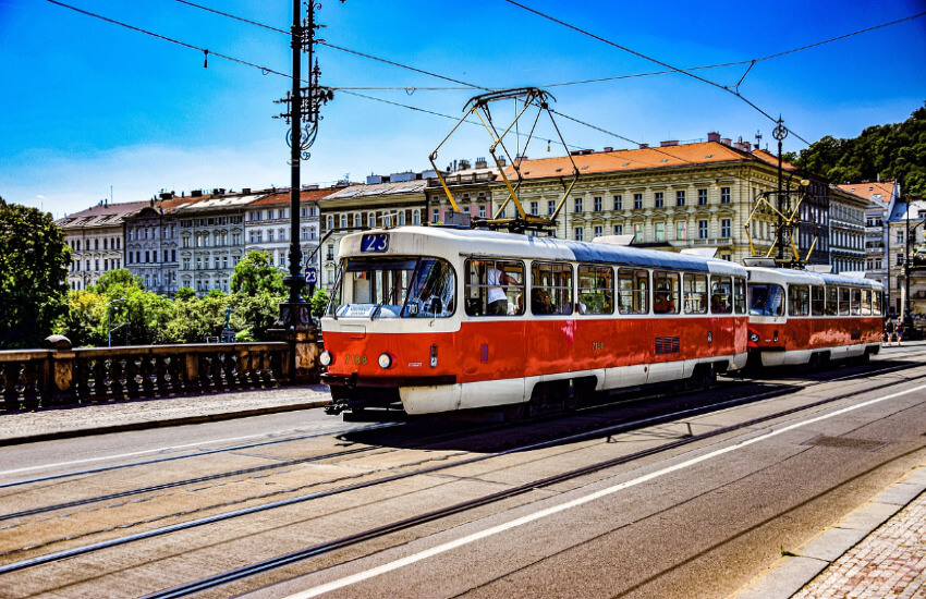 Straßenbahn in Prag Straßenbahn fährt auf Gleisen durch eine Straße in Prag, umgeben historischen Gebäuden.